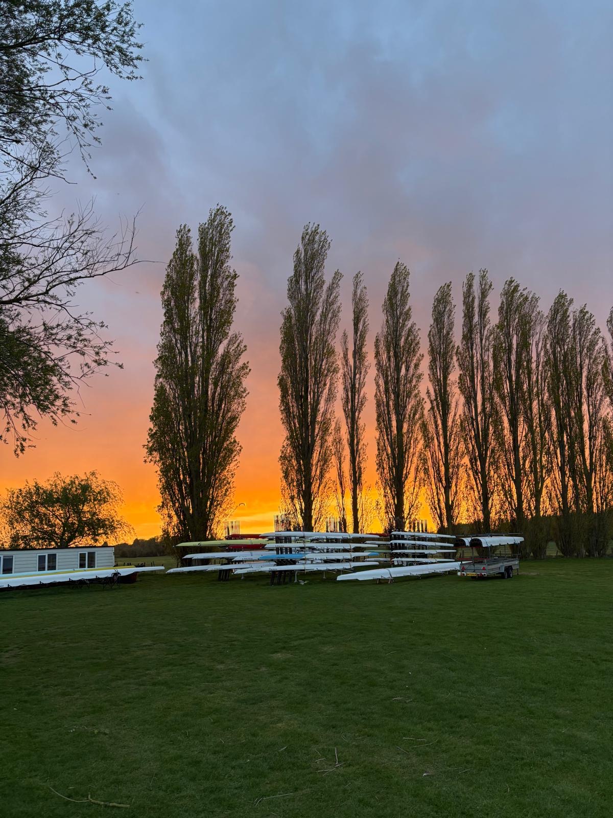 Boats racked outside the Hornets boathouse at sunset on the River Great Ouse